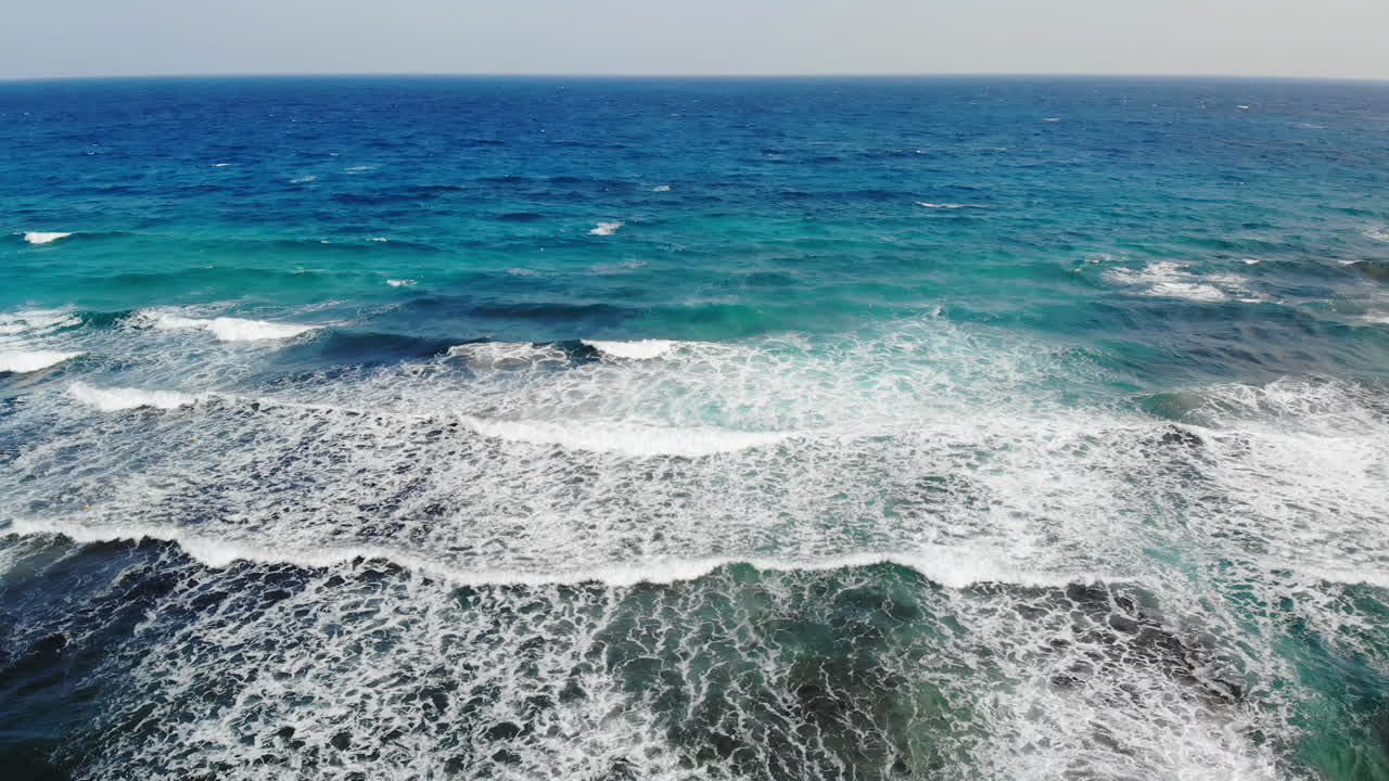 Aerial drone view of waves hitting the rocks on the shore in Limassol, Cyprus
