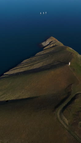 aerial view of a lakeside cape with sailboats