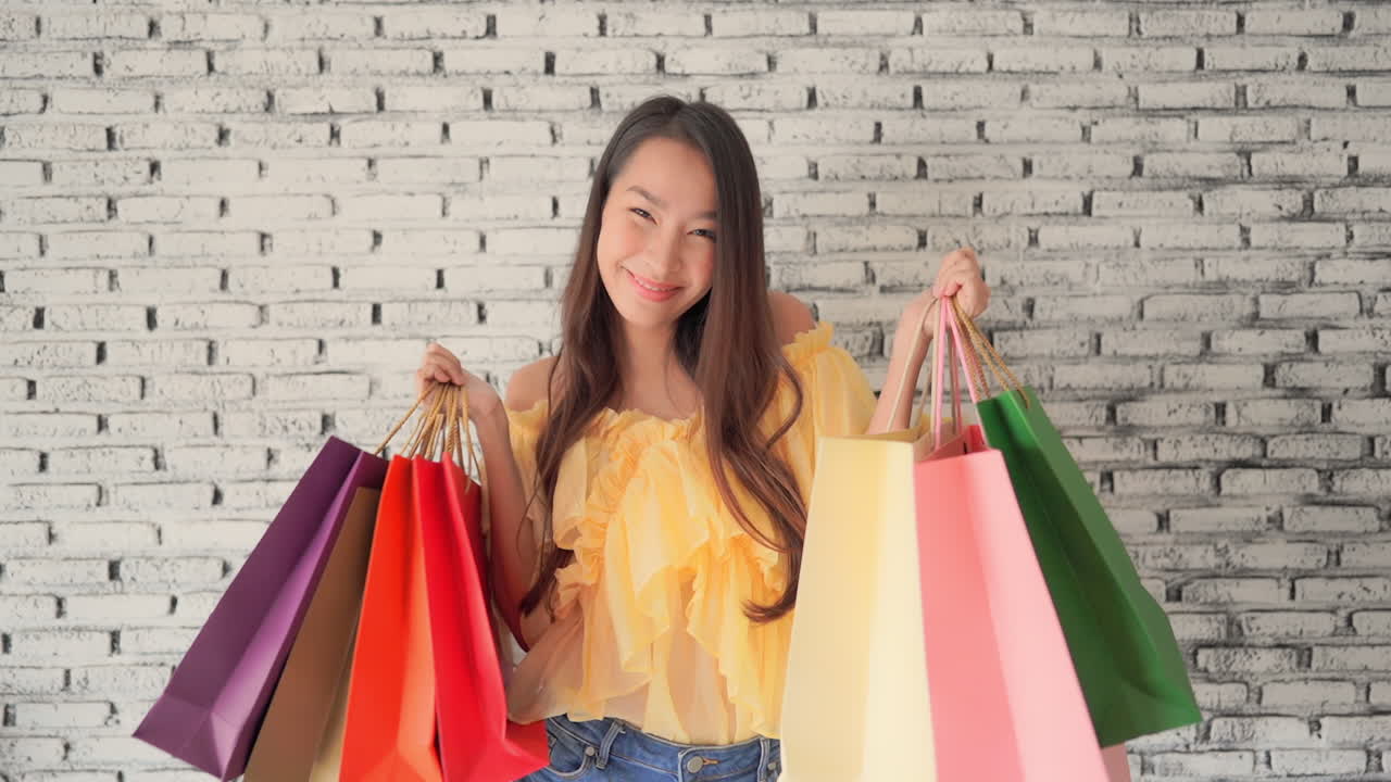 귀여운 아시아 소녀는 그녀의 모든 쇼핑백에 매우 만족합니다