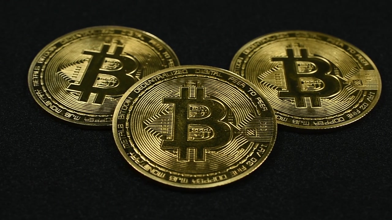 Panoramica di Bitcoin dorati su sfondo nero