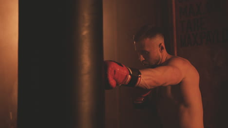 Shirtless-Boxer-Male-Warms-Up-By-Hitting-The-Punching-Bag-1