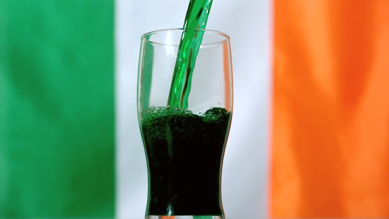 cerveza verde vertiendo en un vaso de pinta