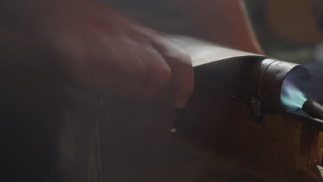 persona formando un trozo de madera con el uso del fuego