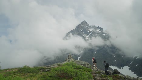 Two-hikers-explore-a-foggy-mountain-trail-with-breathtaking-views-in-Norway