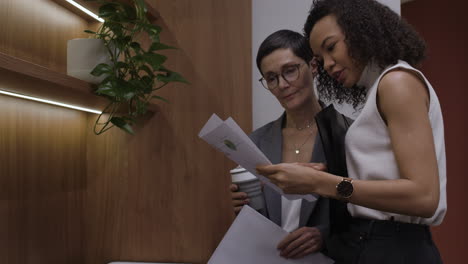 businesswomen reviewing documents in office