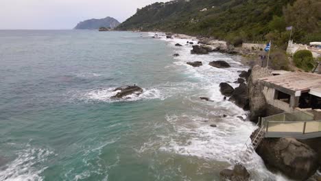 aerial flight over sea waves crushing on rocky beach in slow-motion