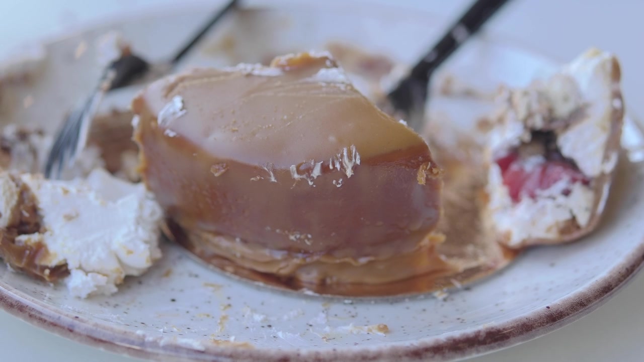 Delvis spist karamellkake og marengsdessert på en tallerken