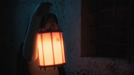 silueta mujer joven mira por la ventana por la noche con una linterna
