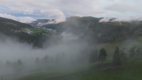 Eine-Ruhige-Luftaufnahme-Zeigt-Einen-Nebelbedeckten-Hügel-Mit-üppigen-Grünen-Bäumen,-Die-Eine-Ruhige-Und-Friedliche-Landschaft-Schaffen