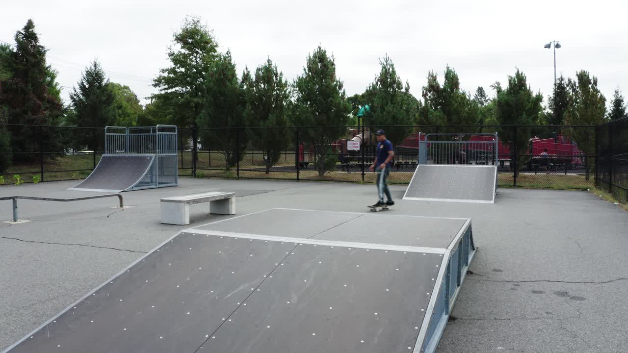 작은 스케이트파크에서 경사로를 타고 내려가는 젊은 히스패닉 스케이터