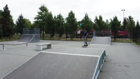 joven patinador hispano bajando por la rampa en un pequeño parque de patinaje