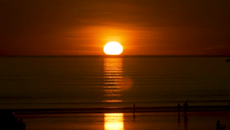 person walking through a sunset spotlight at cable beach, broome, australia