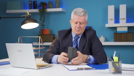 hombre de negocios mostrando su billetera vacía a la cámara.