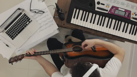 Joven-Músico-Masculino-Creando,-Tocando-Guitarra-Y-Usando-Laptop-En-Casa-1