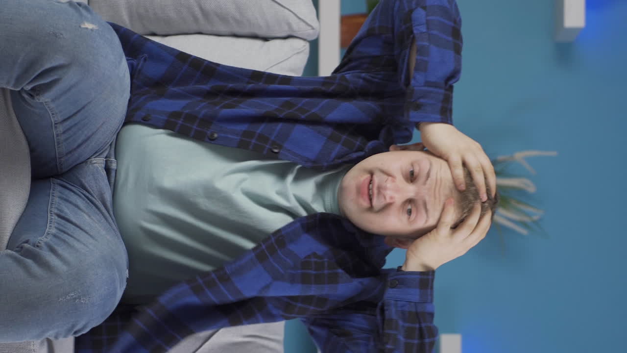 자기 자신에게 화를 내고 결함이 있는 사람의 수직 비디오입니다.