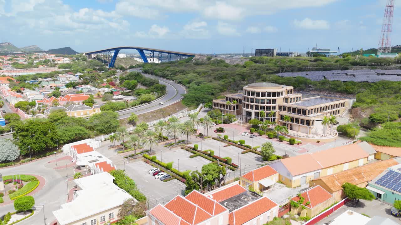 Aerial ascend above Scharloo district neighborhood with Queen Juliana Bridge in backdrop, Willemstad Curacao
