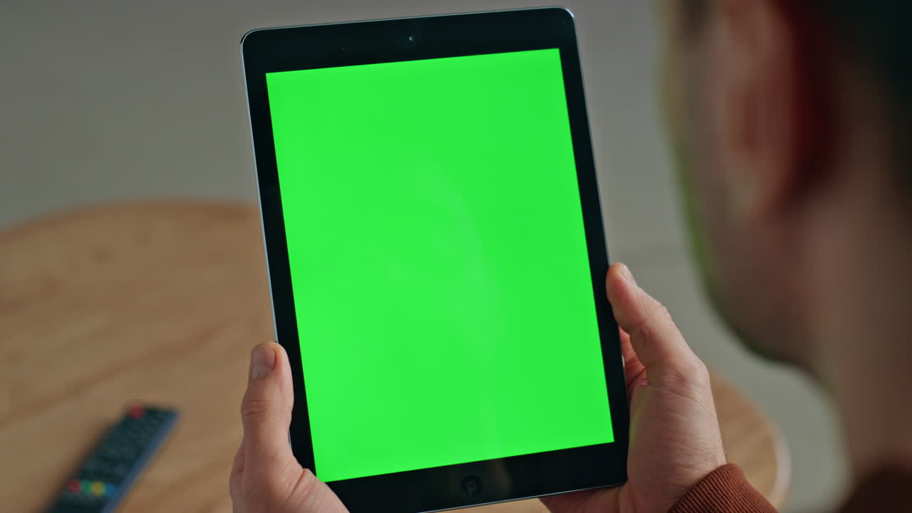 Unknown man watching chroma key tablet at desk closeup. Student holding device