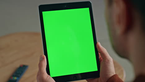 unknown man watching chroma key tablet at desk closeup. student holding device