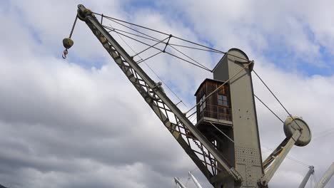 panning clip looking up at large metal crane with blue sky background, at old genoa port, porto antico, italy