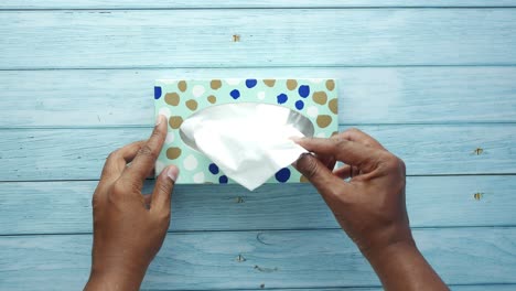 hands taking a tissue from a tissue box