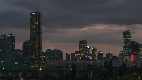 Seoul-at-NIght-lights---63-SQUARE-Skyscraper-Building-With-Hangang-Railway-Bridge-In-Foreground-In-Seoul,-South-Korea