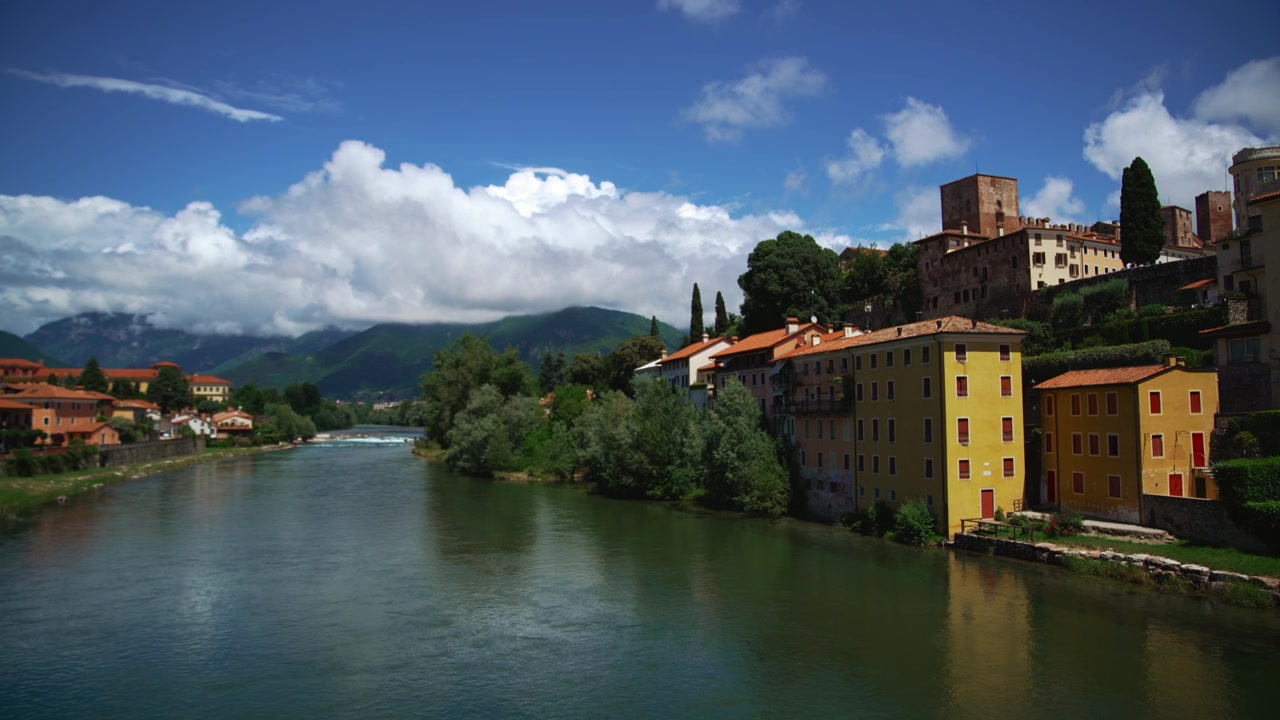 Vista da ponte de madeira Ponte degli Alpini em Bassano del Grappa para o rio em paisagem verde.