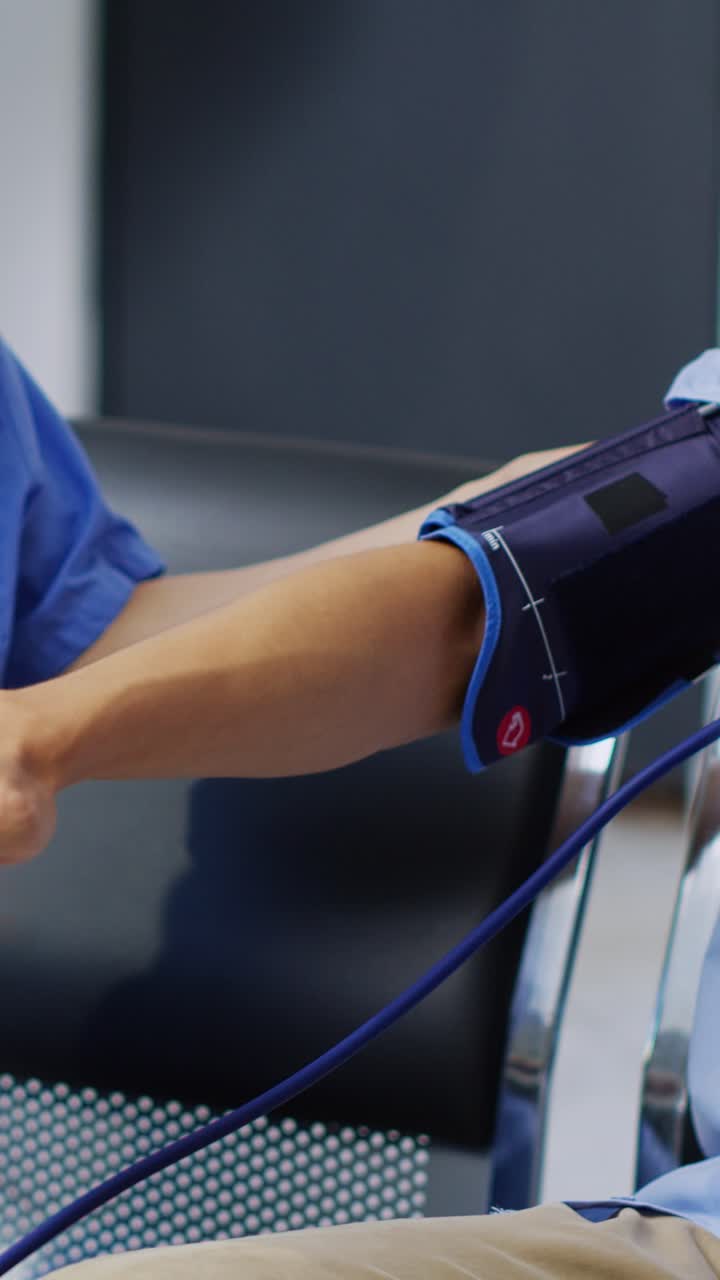 Vertical video: Asian nurse checking patient hypertension