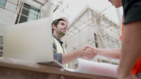 ingeniero civil o arquitecto masculino estrecha la mano con el contratista después de discutir sobre el diseño de estilos de construcción e inspeccionar el progreso del proyecto de vivienda en los sitios de construcción.