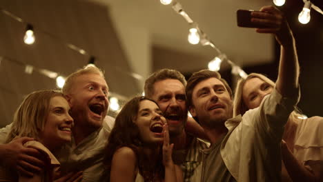 Smiling friends taking selfie photo on mobile phone