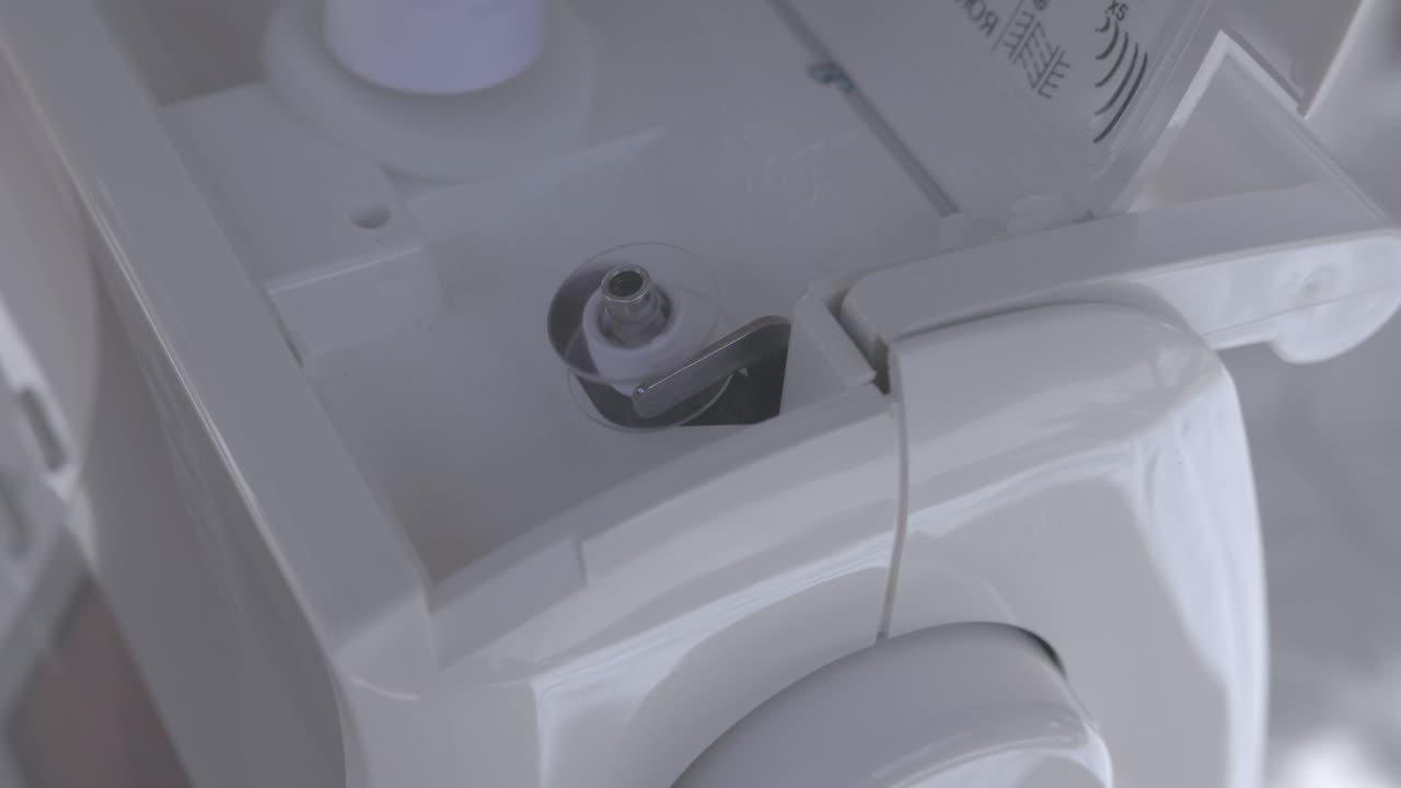 bobbin being filled with white thread ready to use on a sewing machine