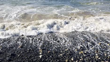 breaking wave on pebble beach.