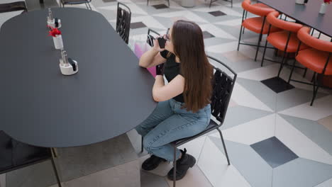 woman talking on phone in a shopping mall restaurant