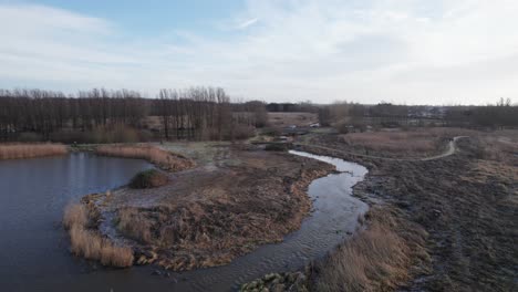 Low-Lever-Flying-Over-Lake-and-Creek-in-a-Rural-Area---Dolly-In-Shot