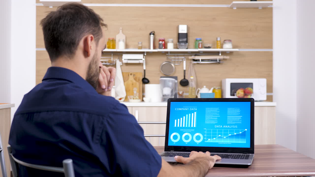 Man working on a laptop in the kitchen