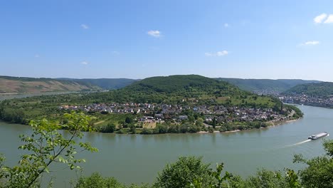 Panning-view-of-Great-Rhine-Loop-in-Boppard,-Germany-with-Cargo-ship-navigating-up-River-at-Bopparder-Hamm-Rheinschleife