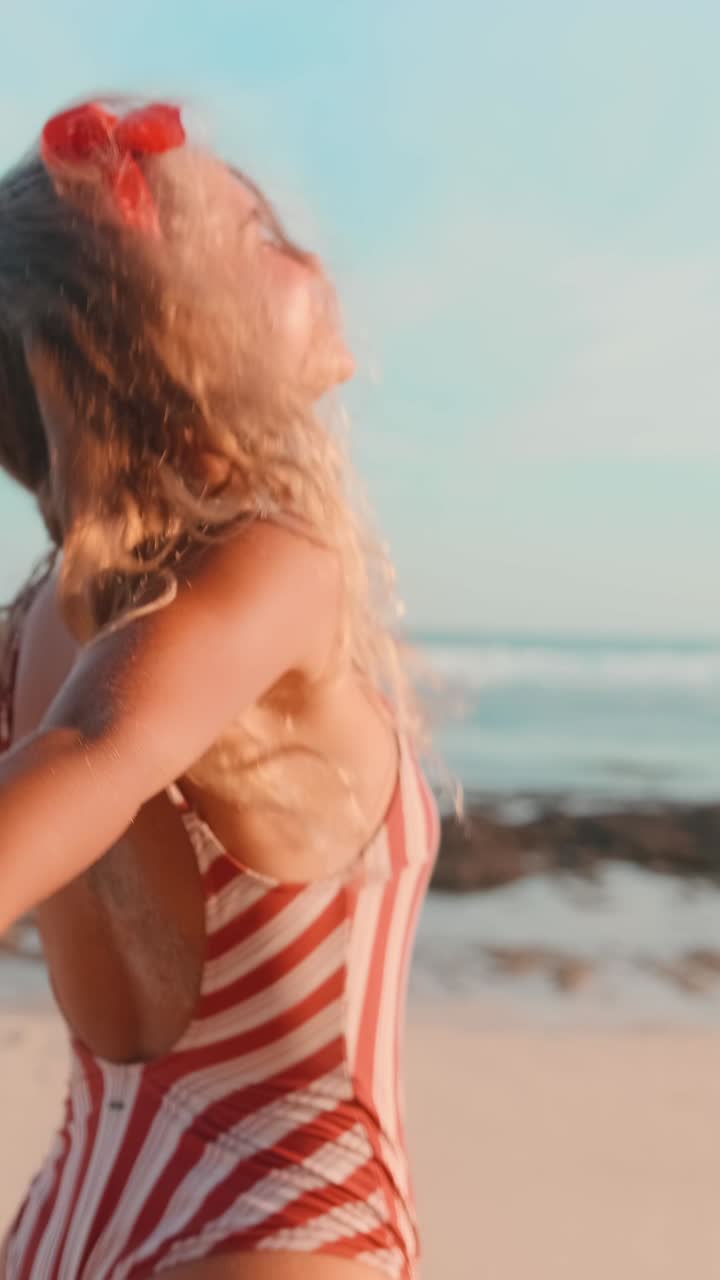 Young laughing caucasian woman runs along sandy beach and holds boyfriend