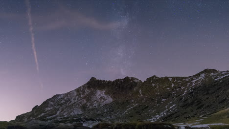 milky way setting behind mountain peaks in guadarrama national park, madrid, spain