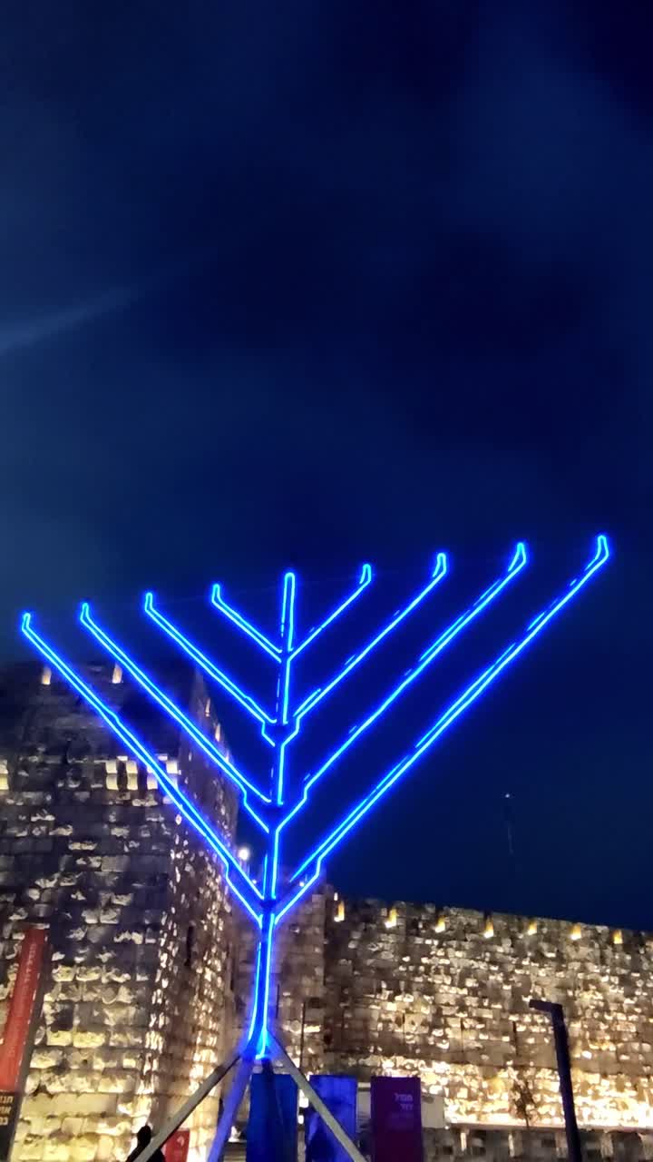 Blue Neon Menorah Against the Night Sky in Jerusalem