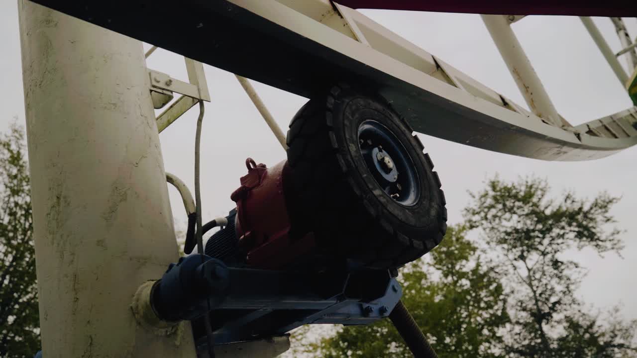 A close-up of an electric motor that rotates a Ferris wheel. Shooting up close in motion
