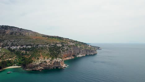 Vista-Aérea-Panorámica:-Vislumbrar-Un-Oasis-Costero-En-Un-Acantilado-Con-Aguas-Turquesas-Y-Playas-Serenas,-Con-El-Majestuoso-Telón-De-Fondo-Del-Monasterio-Del-Arcángel-Miguel,-Thassos,-Grecia