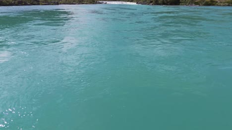 aerial view of a turquoise river flowing between lush green mountains