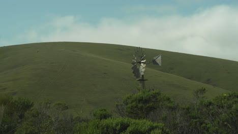 molino de viento frente a las colinas pastorales de california plano amplio 4k