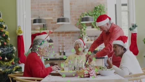 animation of green dots over happy diverse senior friends in santa hats eating together