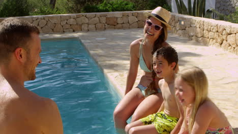 familia de vacaciones relajándose en la piscina al aire libre