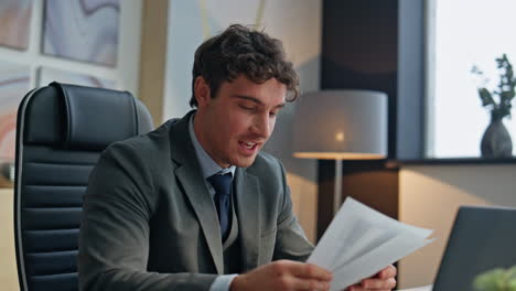 happy boss speaking web conference in office closeup. smiling man showing papers