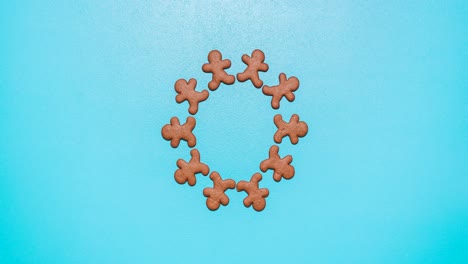 Gingerbread-man-cookies-moving-on-a-blue-table,-stop-motion-animation