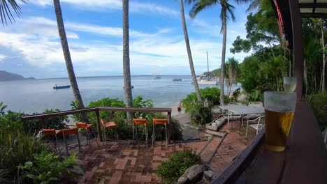 Timelapse-view-of-Palm-trees-and-ocean-view-with-boats-going-by-and-drinking-beer