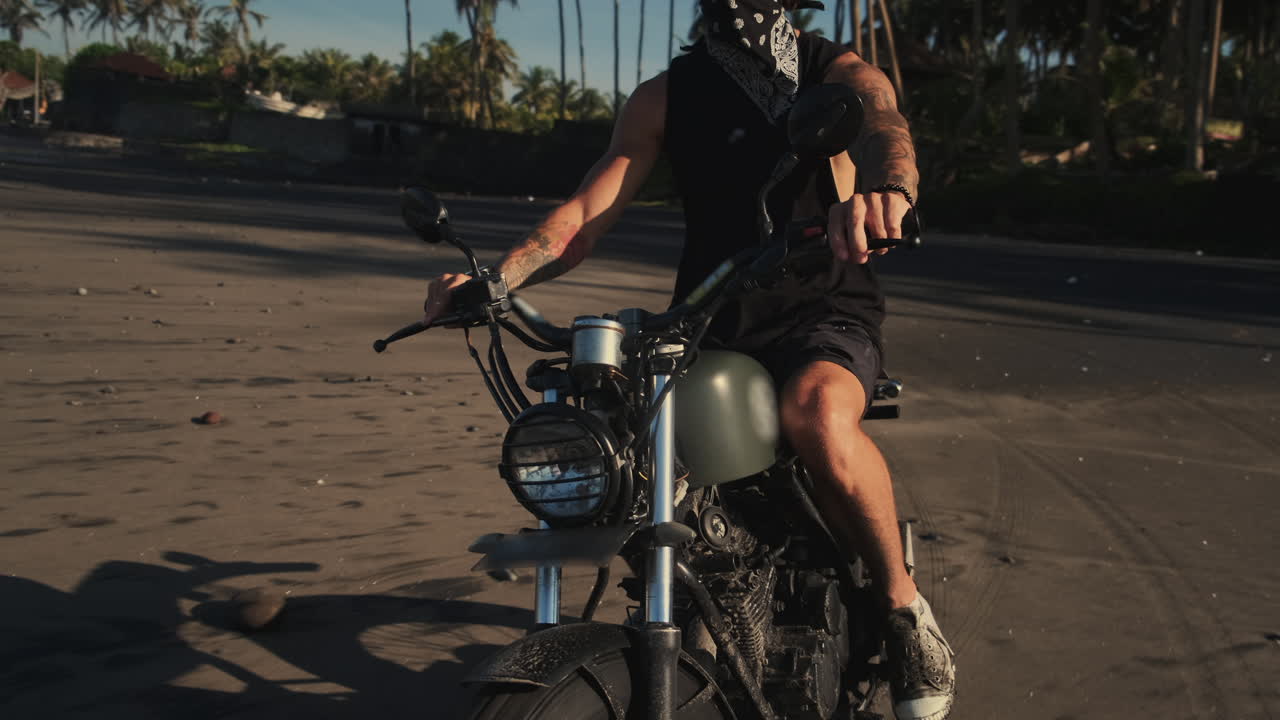 Man on Motorcycle on a Black Sand Beach