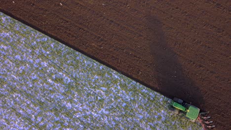 tractor is plowing a field with frost