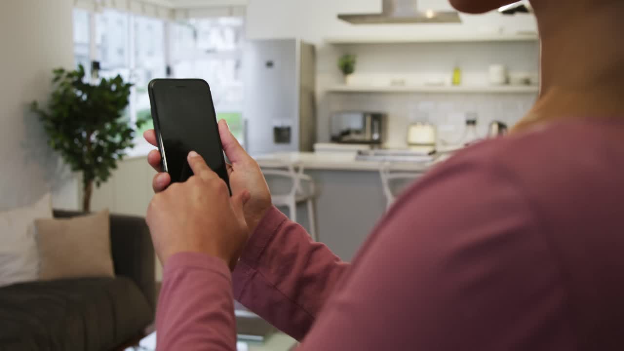 mujer usando un teléfono inteligente en la cocina